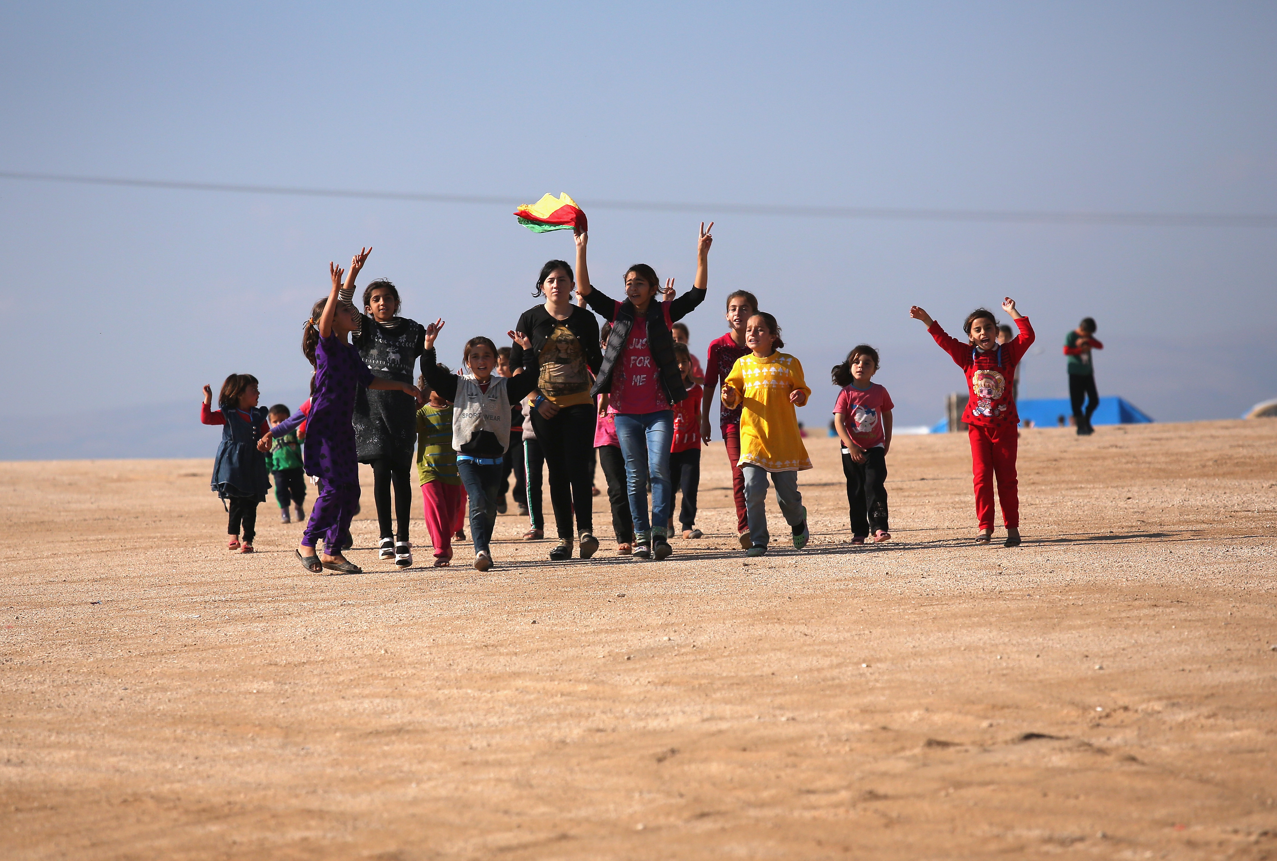 Yazidi refugees celebrate news of the liberation of their homeland of Sinjar from ISIL extremists, while at a refugee camp on November 13, 2015, in Derek, Rojava, Syria. Kurdish Peshmerga forces in Iraq say they have retaken Sinjar, with the help of airstrikes from U.S. led coalition warplanes. (Getty Images)
