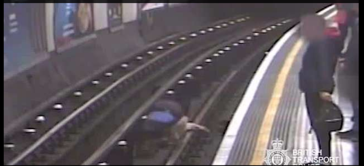 Sir Robert can be seen lying on the tracks as the Frenc teacher jumps down to help him.