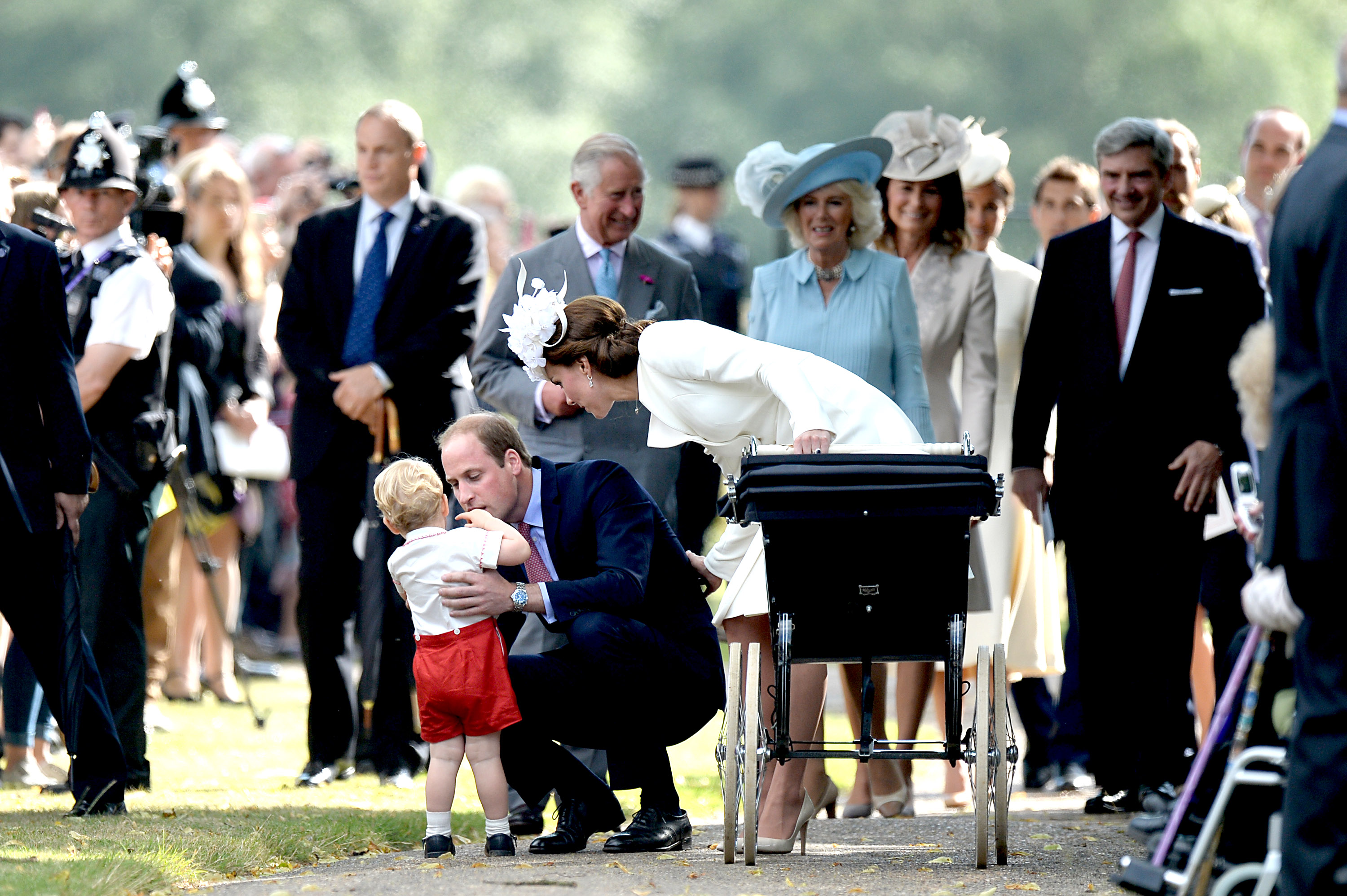 Prince Charles, Prince of Wales, Camilla, Duchess of Cornwall and Carole Middleton walk behind Catherine, Duchess of Cambridge, Prince William, Duke of Cambridge, Princess Charlotte of Cambridge and Prince George of Cambridge leaving the Church of St Mary Magdalene on the Sandringham Estate after the Christening of Princess Charlotte of Cambridge on July 5, 2015 in King's Lynn, England.
