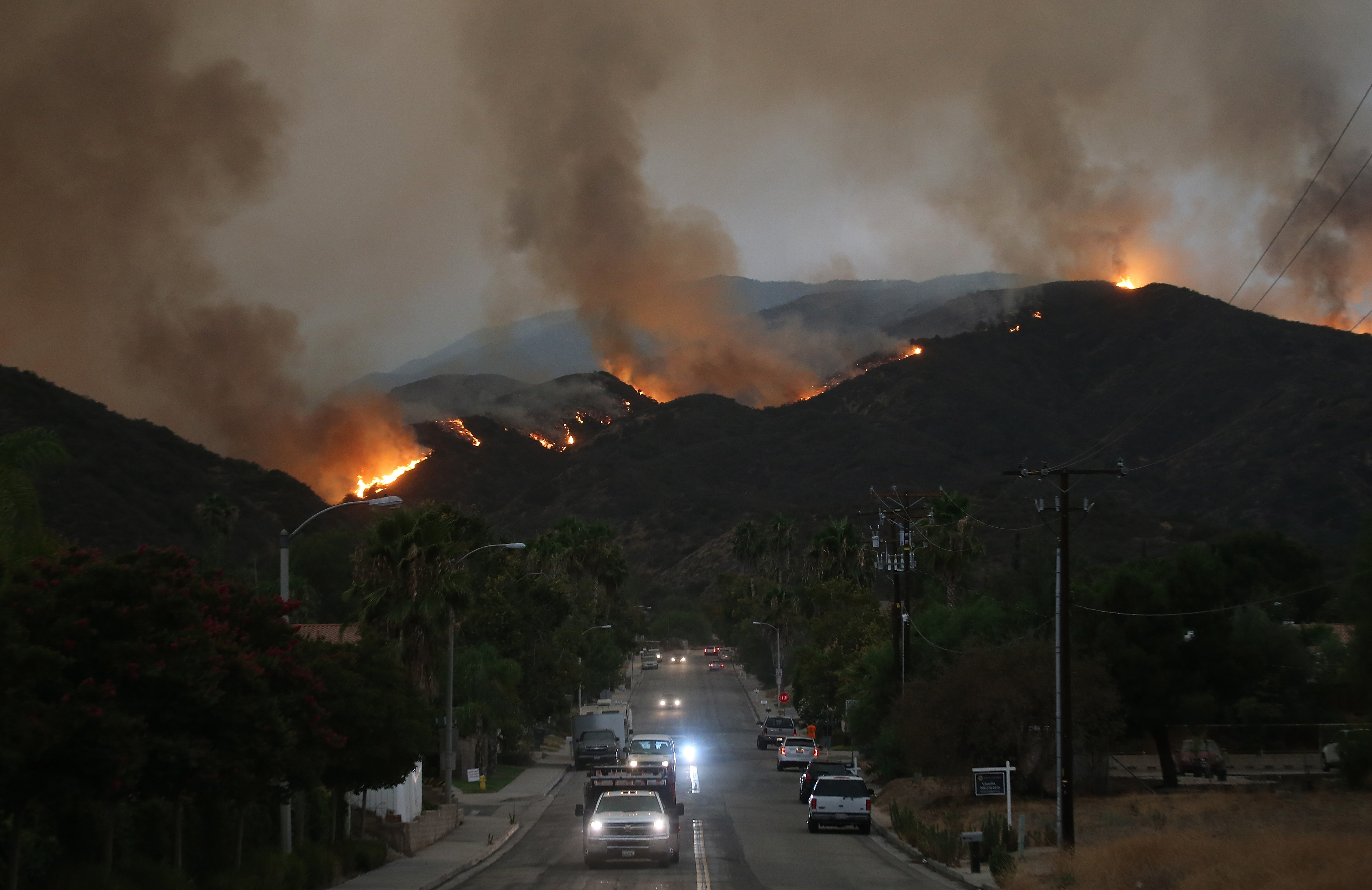 Cars drive down a hill in a mandatory evacuation area as the Holy Fire burns in Cleveland National Forest on August 8, 2018 in Lake Elsinore, California. The fire has burned at least 6,200 acres and destroyed twelve structures.