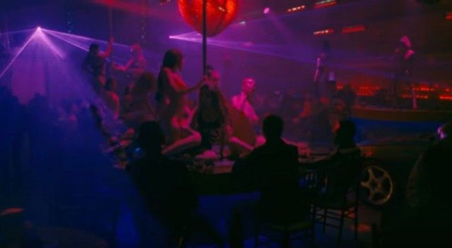 A still from the video shows Miley drive through a strip club. (Image Source: Youtube)
