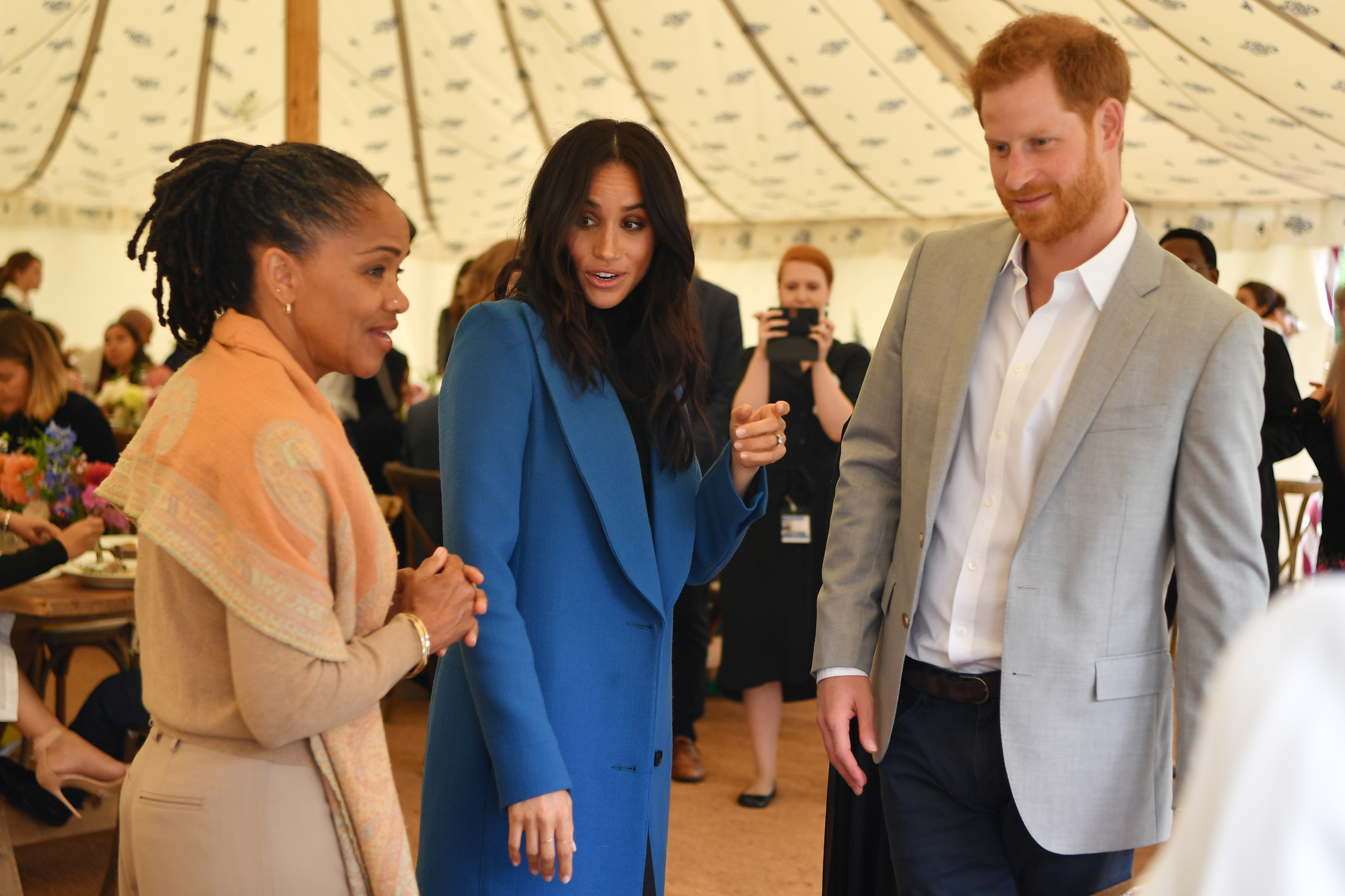 Meghan, Duchess of Sussex (C) arrives with her mother Doria Ragland (L) and Prince Harry, Duke of Sussex to host an event to mark the launch of a cookbook with recipes from a group of women affected by the Grenfell Tower fire at Kensington Palace on September 20, 2018 in London, England.