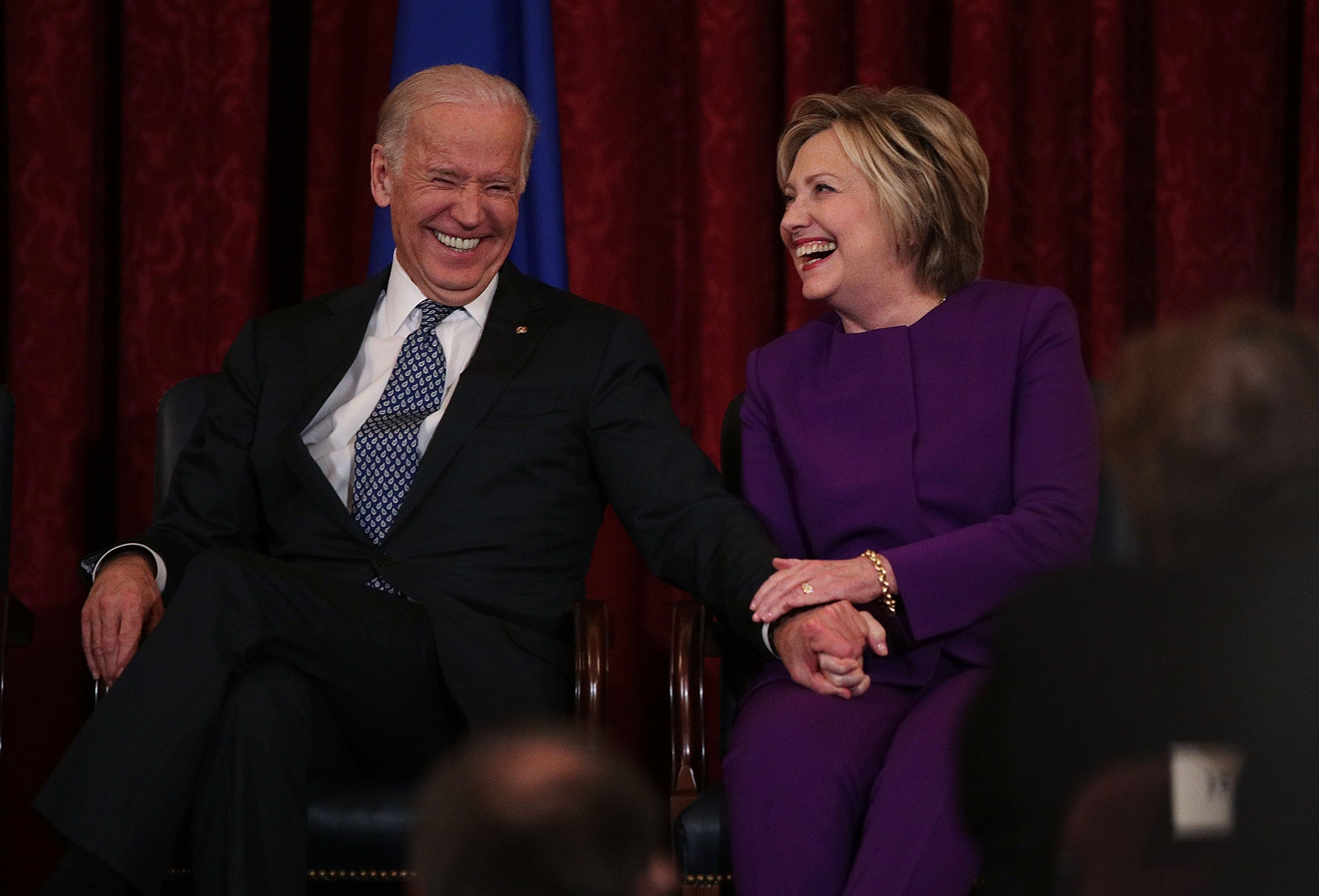 Former U.S. Secretary of State Hillary Clinton (R) shares a moment with Vice President Joseph Biden (L) during a leadership portrait unveiling ceremony for Senate Minority Leader Sen. Harry Reid (D-NV) December 8, 2016 on Capitol Hill in Washington, DC. The leadership portrait unveiling ceremony was held to honor the outgoing Democratic leader.