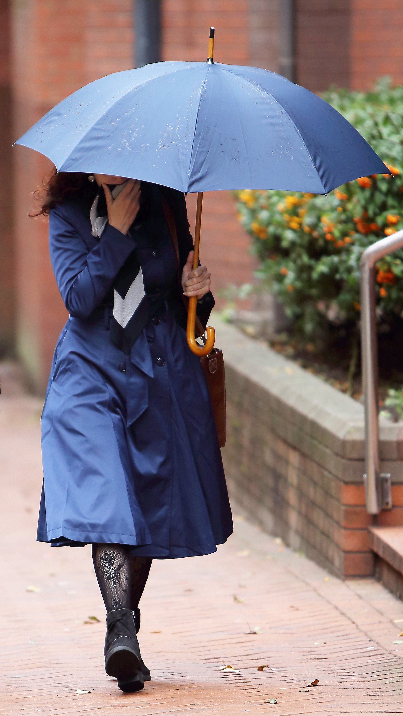 Claudia Patatas, 38, attempting to cover her face with a scarf, as she arrives at Birmingham Crown Court (Source: SWNS)