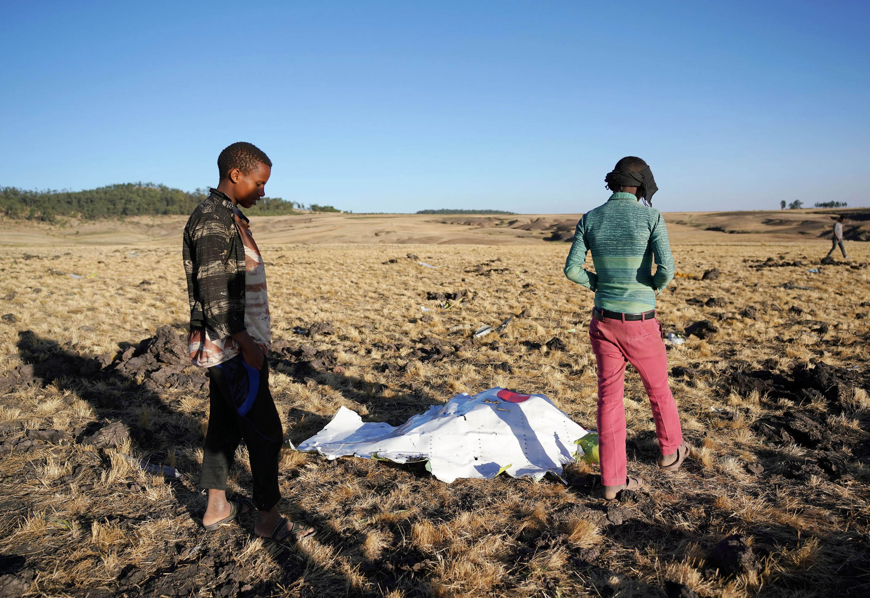 Local residents look at debris at the scene where Ethiopian Airlines Flight 302 crashed in a wheat field just outside the town of Bishoftu, 62 kilometers southeast of Addis Ababa on March 10, 2019, in Addis Ababa, Ethiopia. (Getty)