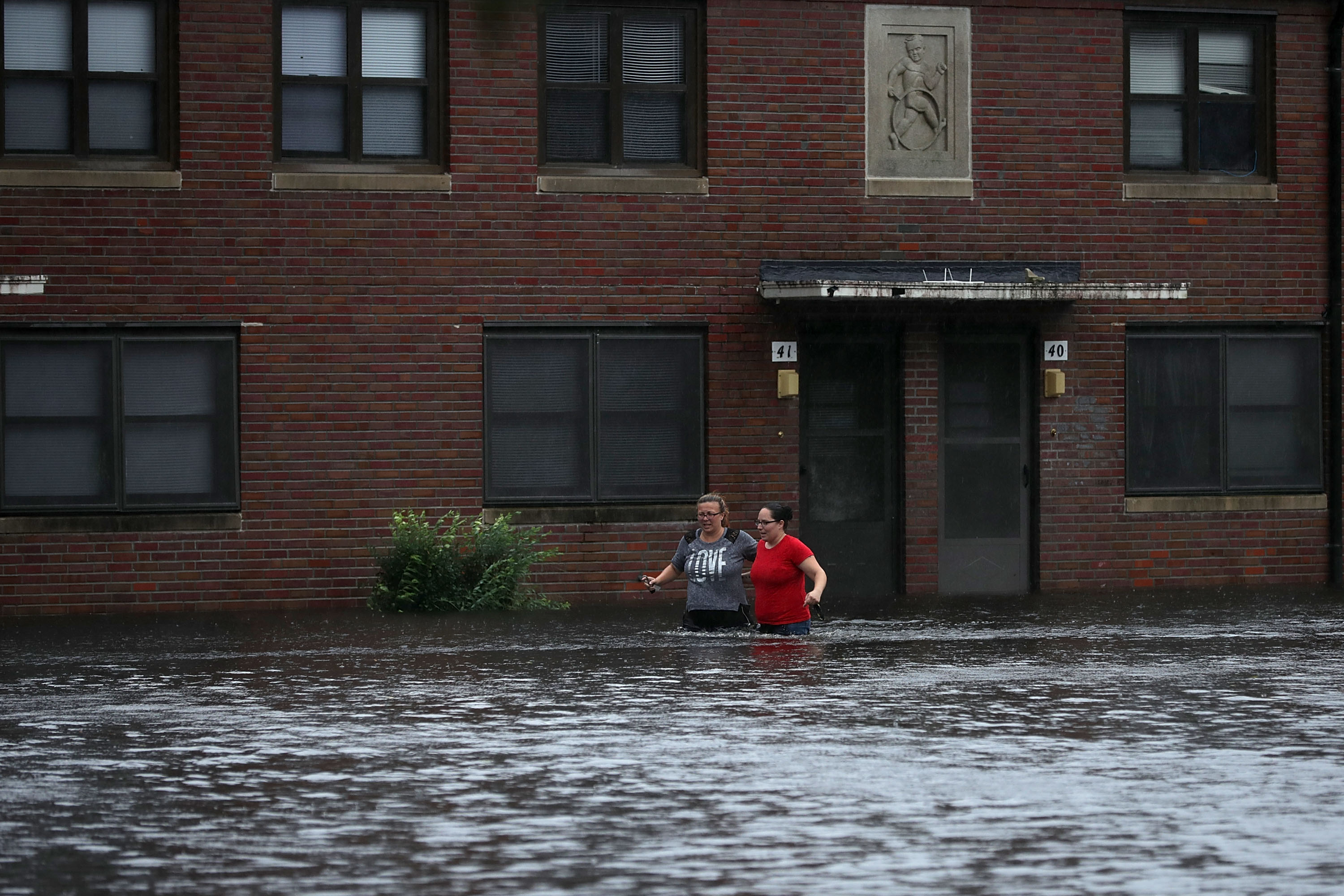 Residents wade through deep floodwater to retrieve belongings from the Trent Court public housing apartments after the Neuse River went over its banks during Hurricane Florence September 13, 2018 in New Bern, United States. Coastal cities in North Carolina, South Carolina and Virginia are under evacuation orders as the Category 2 hurricane approaches the United States.