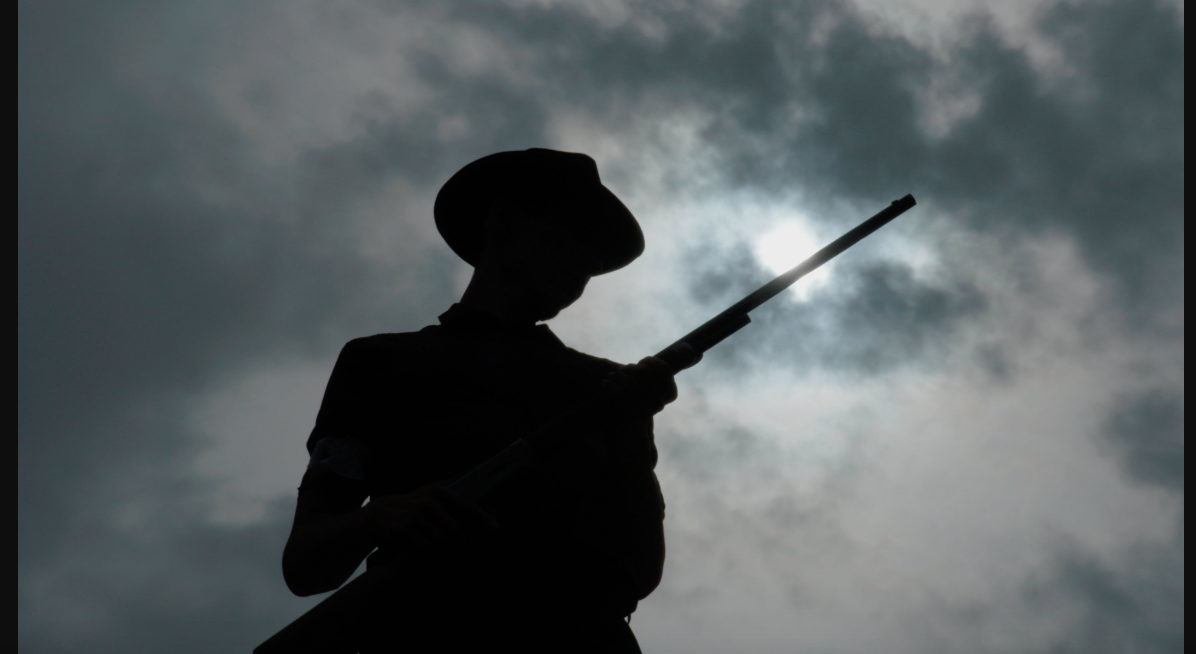A still of a deputized townsmen out to round up striking immigrants from Bisbee'17.