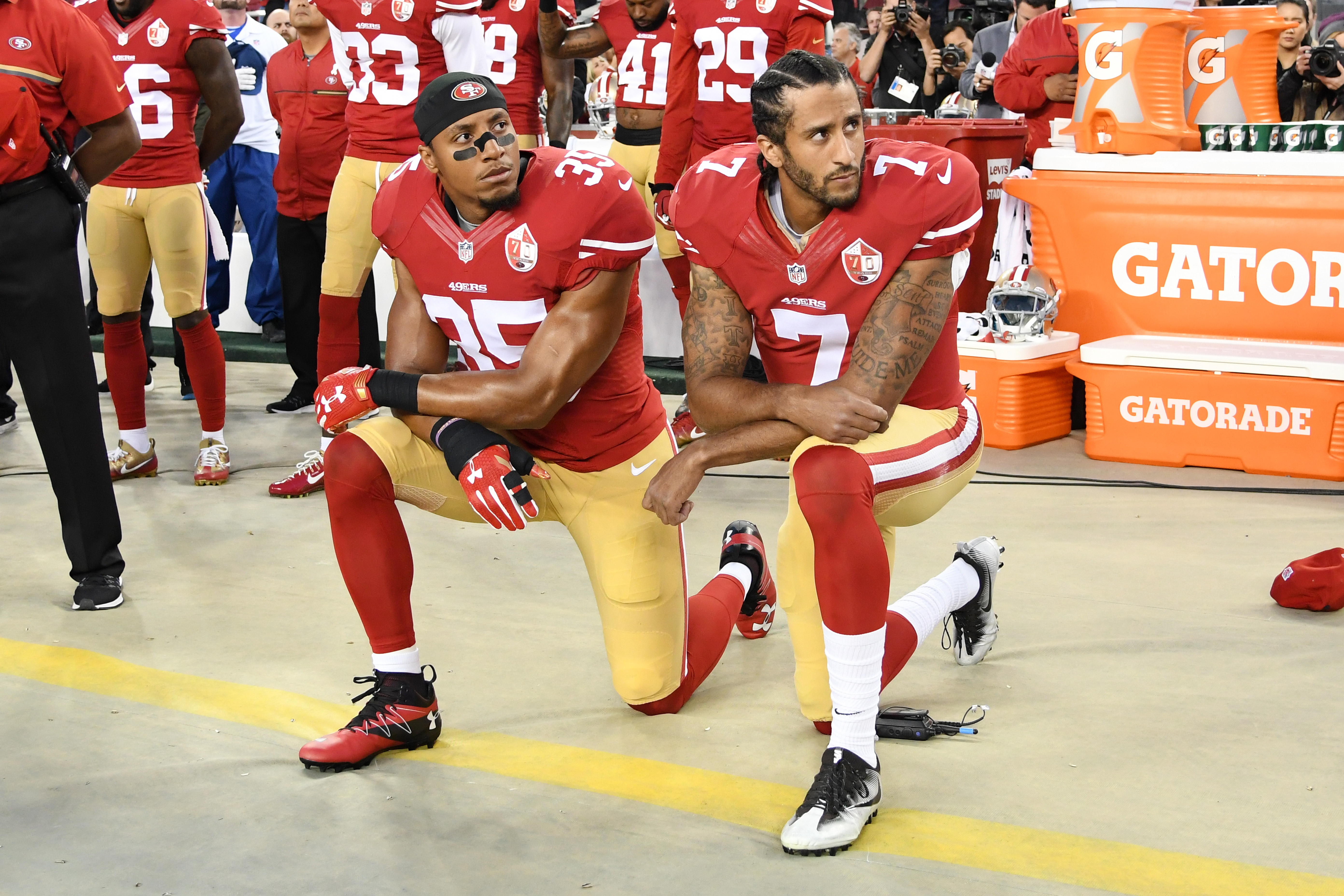 Colin Kaepernick #7 and Eric Reid #35 of the San Francisco 49ers kneel in protest during the national anthem prior to playing the Los Angeles Rams in their NFL game at Levi's Stadium on September 12, 2016 in Santa Clara, California. (Image Source: Getty)