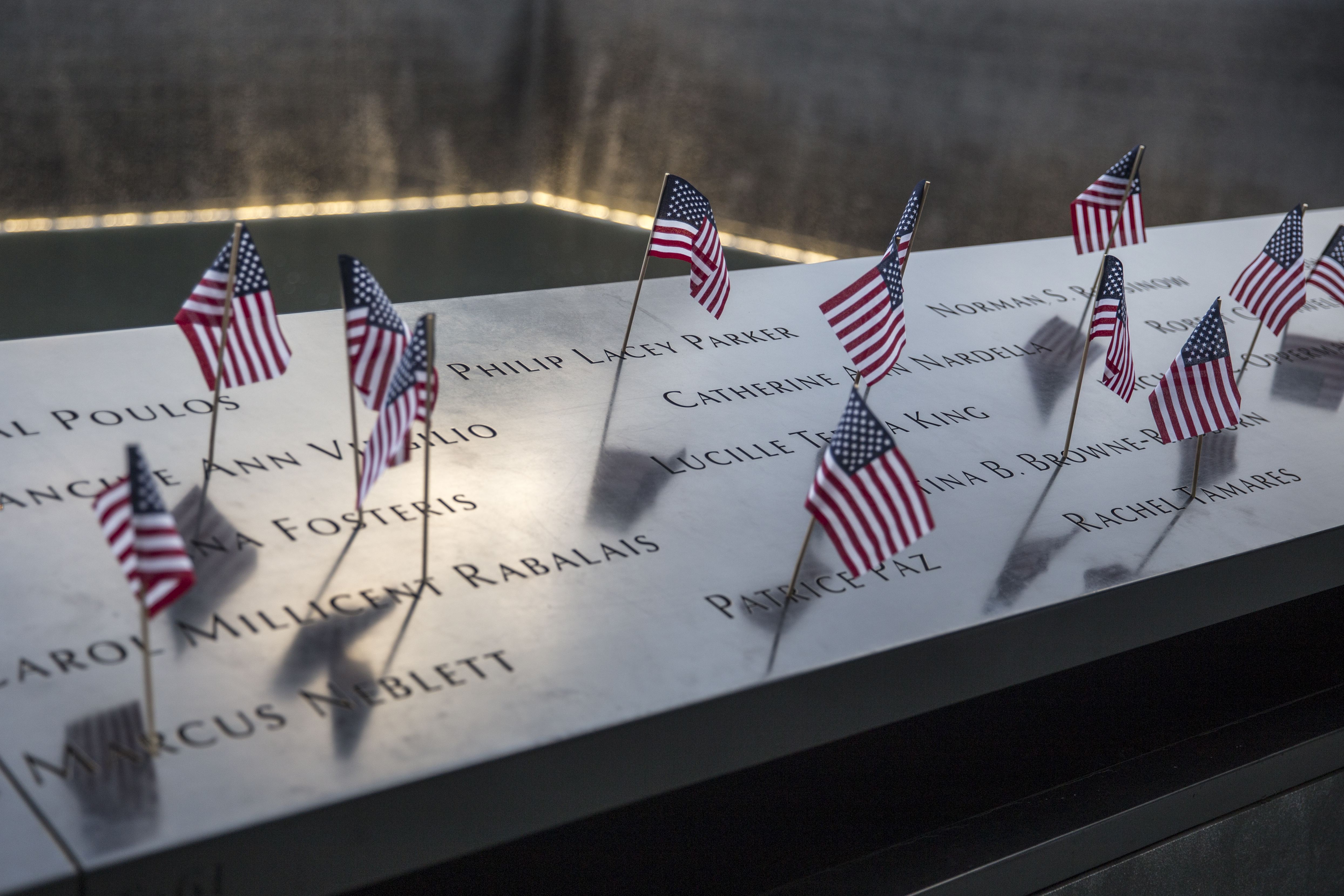 Small American flags are placed in all 2,983 names on the 9/11 Memorial on July 4, 2017, in the Manhattan borough of New York City. The flag placement has become an annual tradition at the site on July 4 (Source: Getty Images)