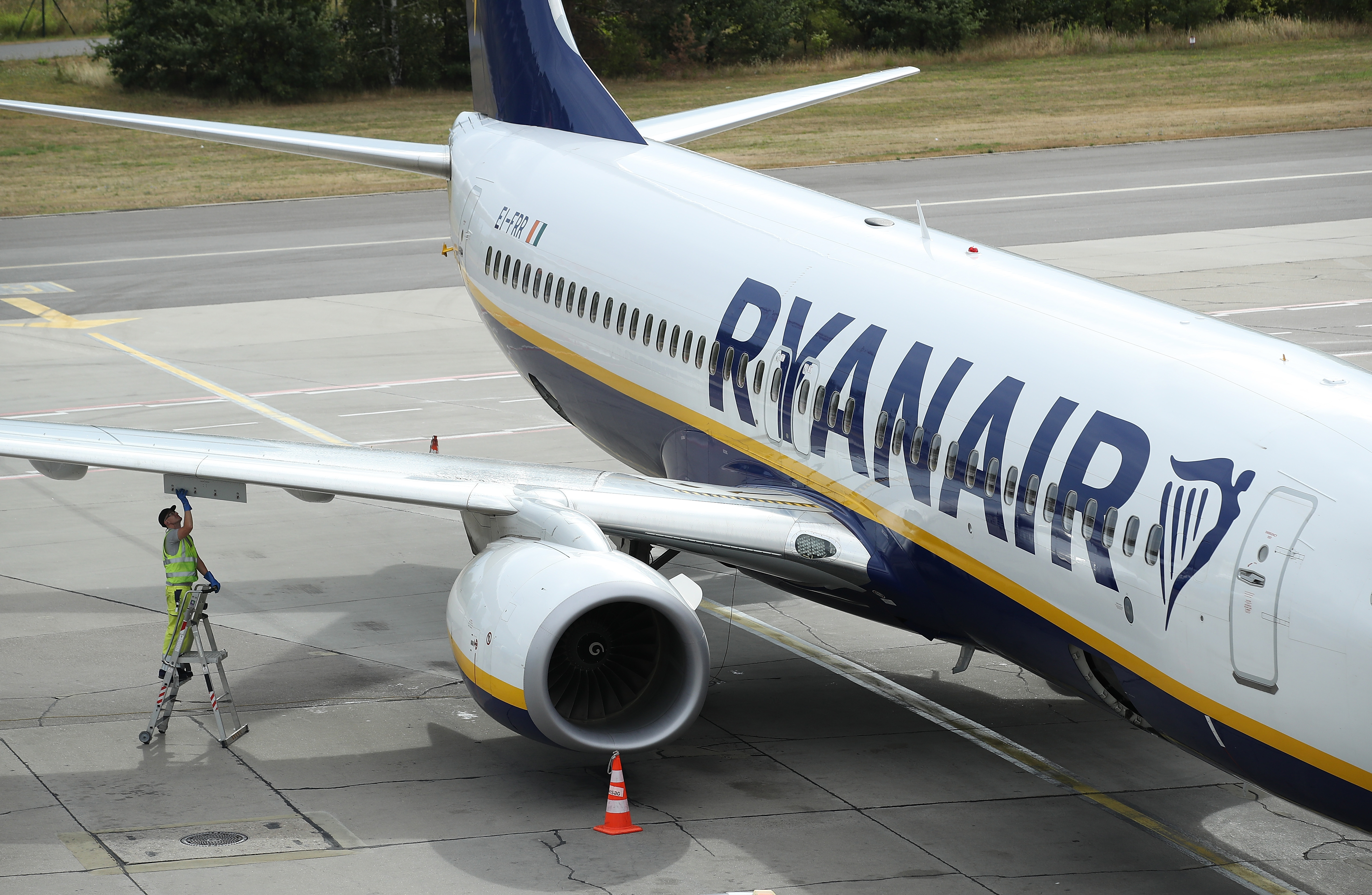 A ground crew worker stands on a ladder at a RyanAir passenger plane at Schoenefeld Airport near Berlin during a 24-hour strike by RyanAir pilots on August 10, 2018, in Schoenefeld, Germany. (Getty)