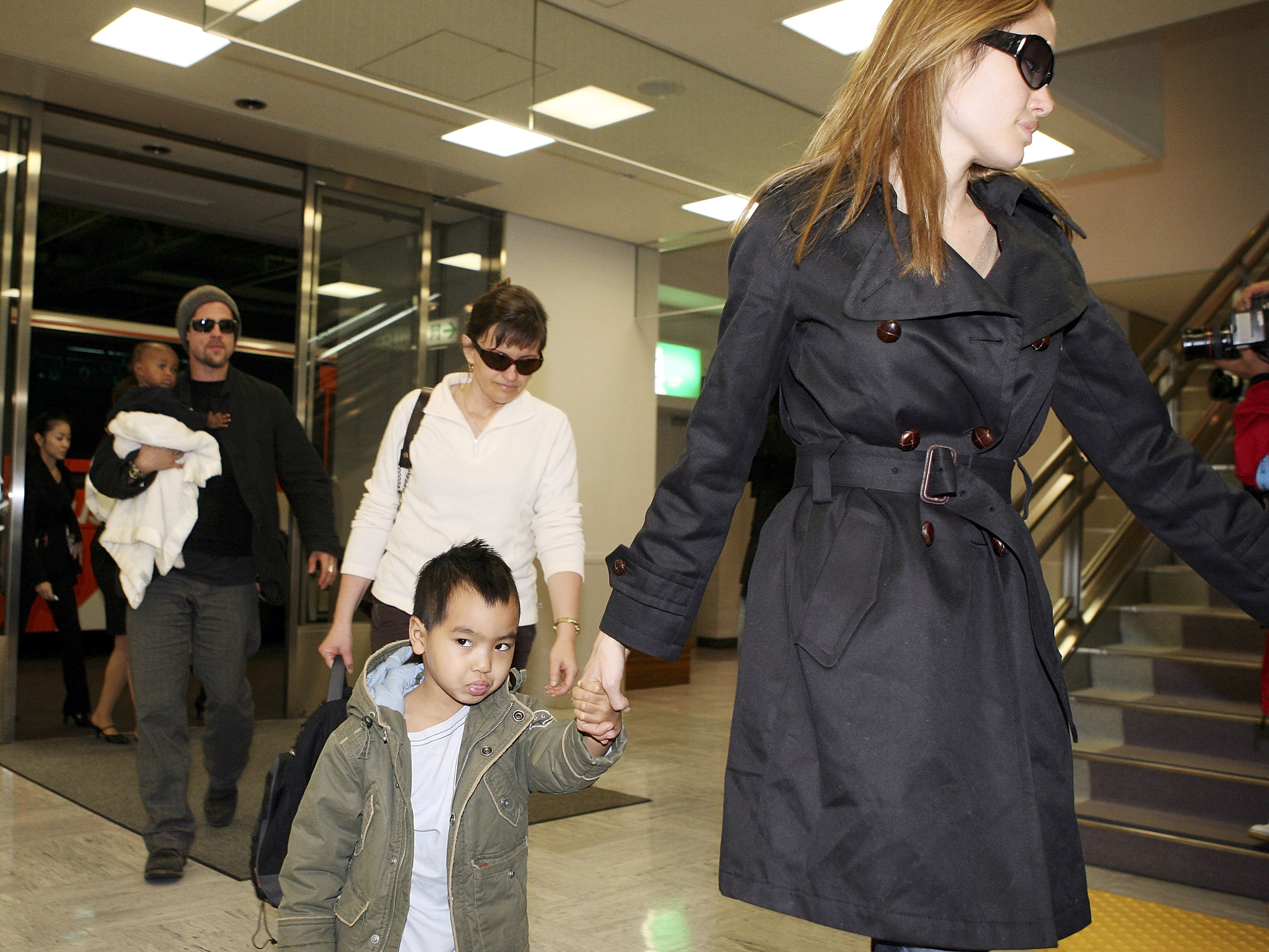 Actor Brad Pitt (L) and actress Angelina Jolie (R) arrive with Jolie's children Zahara Marley Jolie and Maddox Jolie at the New Tokyo International Airport on November 27, 2005 in Narita, Japan. (Photo by Koichi Kamoshida/Getty Images)