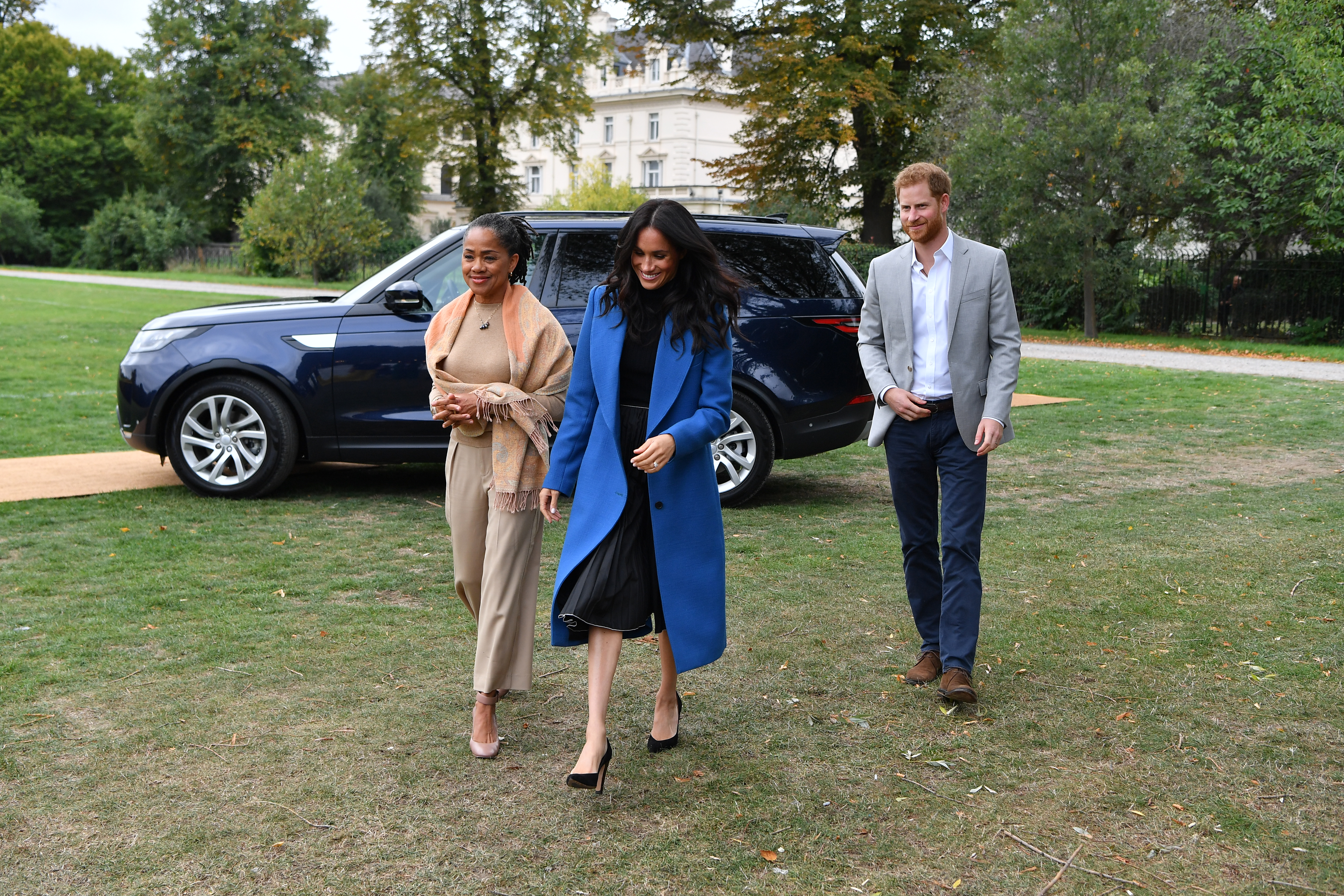 Meghan, Duchess of Sussex (C) arrives with her mother Doria Ragland (L) and Prince Harry, Duke of Sussex to host an event to mark the launch of a cookbook with recipes from a group of women affected by the Grenfell Tower fire at Kensington Palace on September 20, 2018 in London, England.