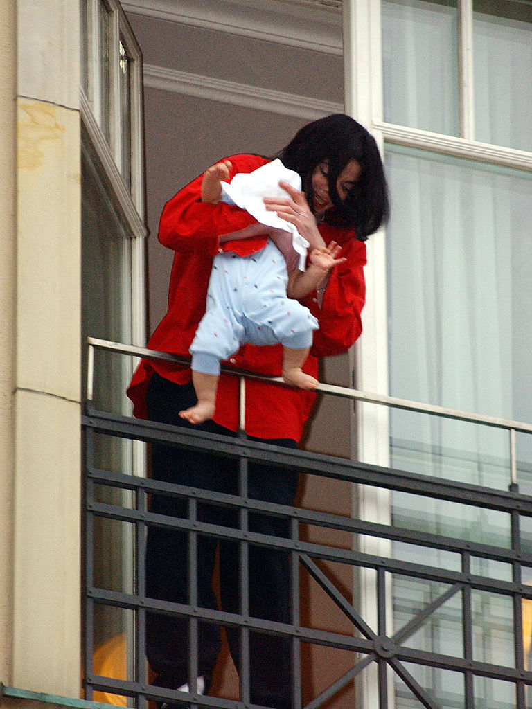 Singer Michael Jackson holds his eight-month-old son Prince Michael II over the balcony of the Adlon Hotel November 19, 2002 in Berlin, Germany. (Photo by Olaf Selchow/Getty Images)