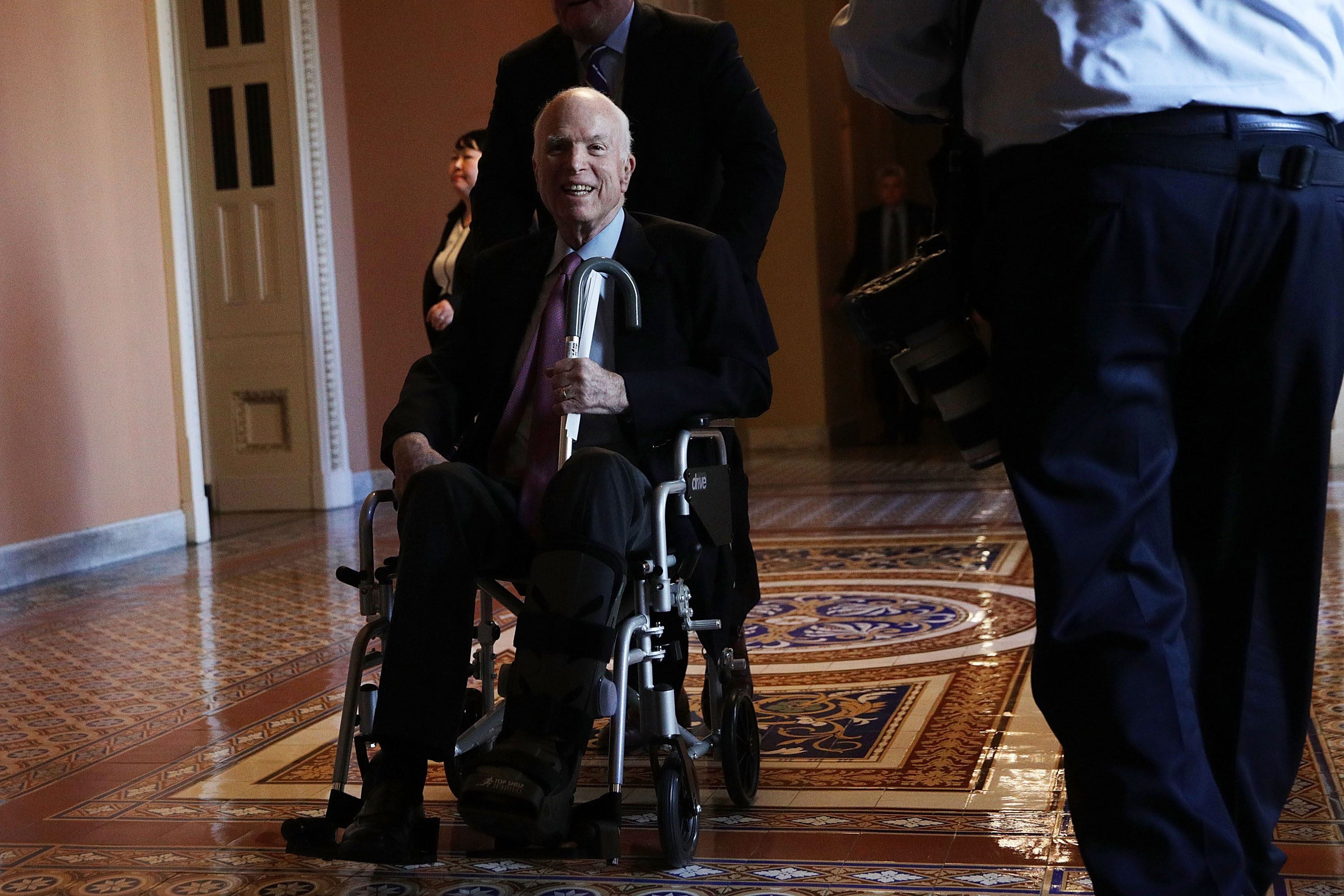 U.S. Sen. John McCain (R-AZ) passes by on a wheelchair in a hallway at the Capitol December 1, 2017 in Washington, DC. Senate GOPs indicate that they have enough votes to pass the tax reform bill. (Getty Images)