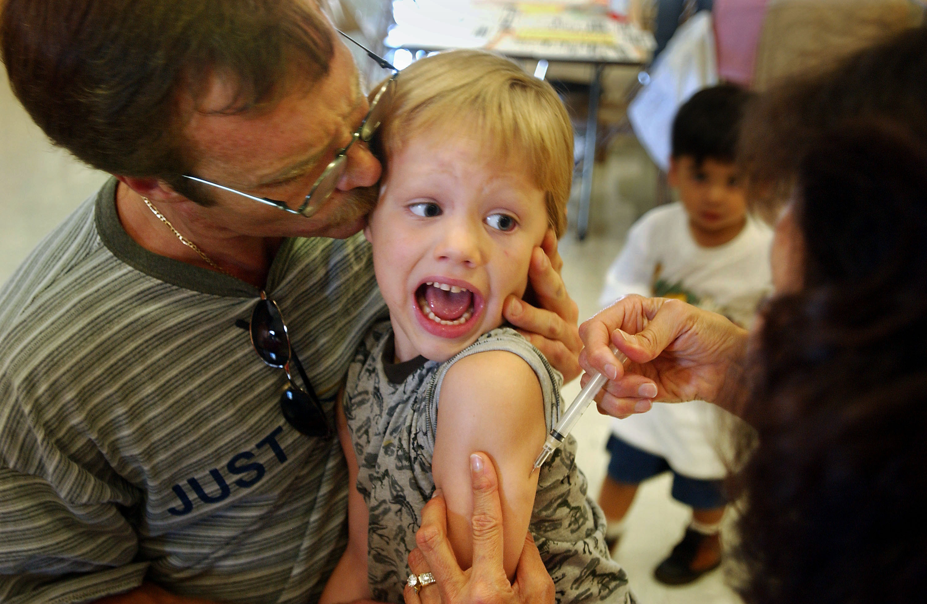 Incoming kindergartener Jeremy Conner, 5, reacts to a Measles, Mumps and Rubella vaccination (MMR) as his father Mark Conner tries to comfort him August 26, 2002 in Santa Ana, California. Nurses are immunizing children in preparation for the first day of public school. (Getty Images)