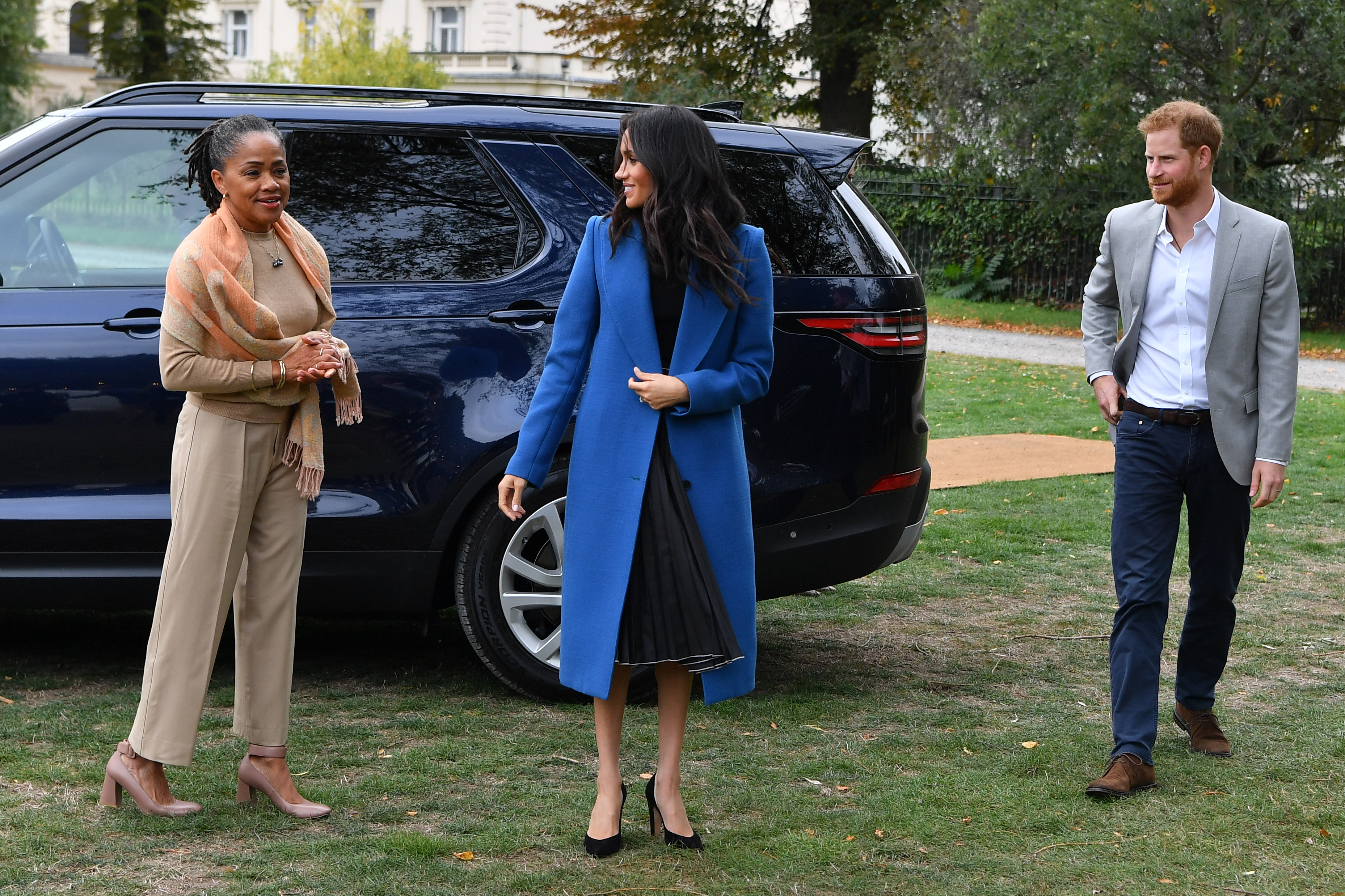 Meghan, Duchess of Sussex (C) arrives with her mother Doria Ragland (L) and Prince Harry, Duke of Sussex to host an event to mark the launch of a cookbook with recipes from a group of women affected by the Grenfell Tower fire at Kensington Palace on September 20, 2018 in London, England.