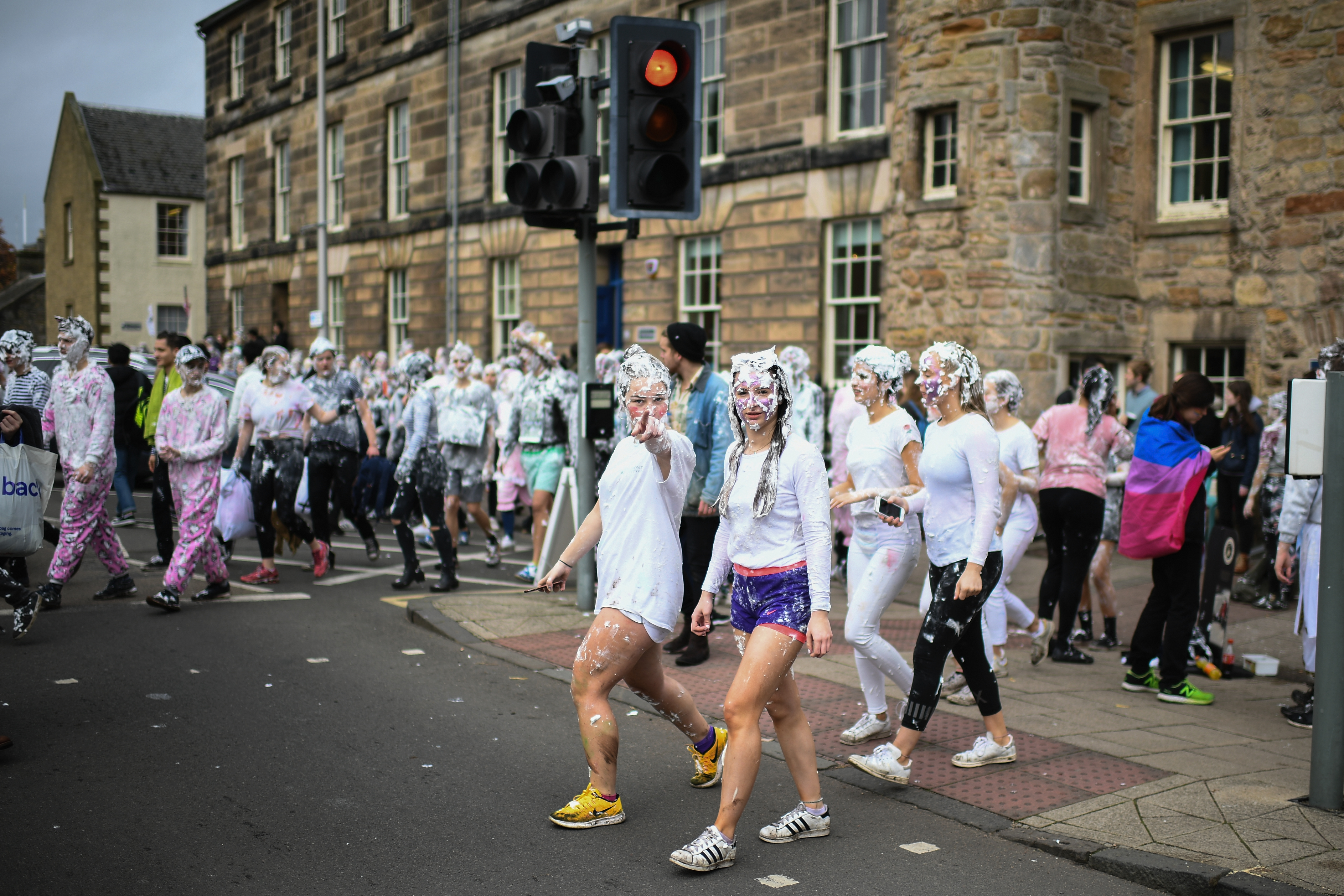 Students from St Andrews University indulge in a tradition of covering themselves with foam to honour the 'academic family' on the lower college lawn on October 23, 2017, in St Andrews, Scotland. The 'raisin weekend' stems from a gift of raisins (now flour and foam) traditionally given by a first year student to their academic 'parents' in gratitude for their guidance.