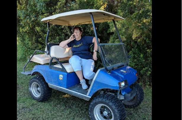 The woman can be seen sitting on a golf cart calling the cops.