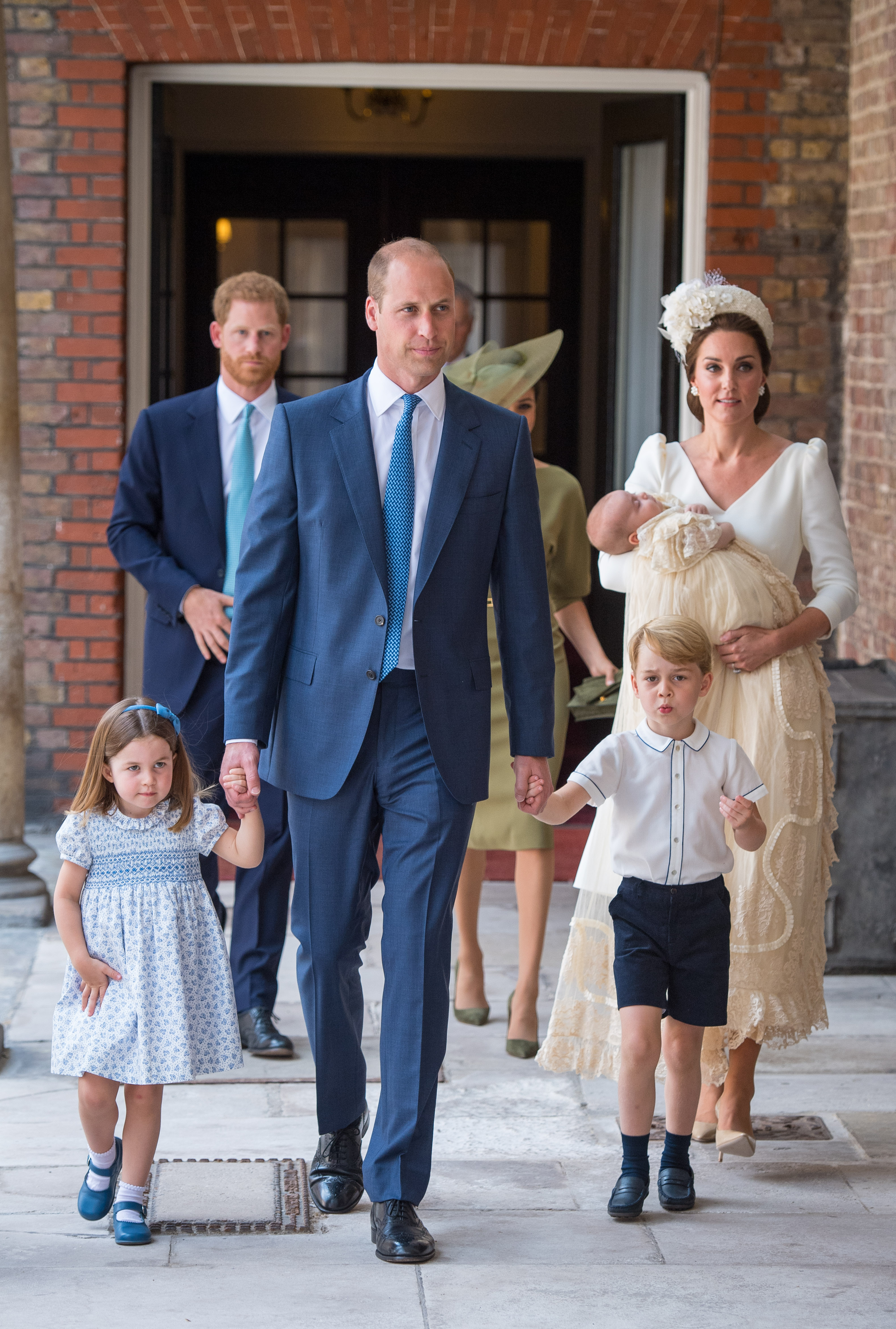 Princess Charlotte and Prince George hold the hands of their father, Prince William, Duke of Cambridge, as they arrive at the Chapel Royal, St James's Palace, London for the christening of their brother, Prince Louis, who is being carried by their mother, Catherine, Duchess of Cambridge on July 09, 2018 in London, England. (Photo by Dominic Lipinski - WPA Pool/Getty Images)