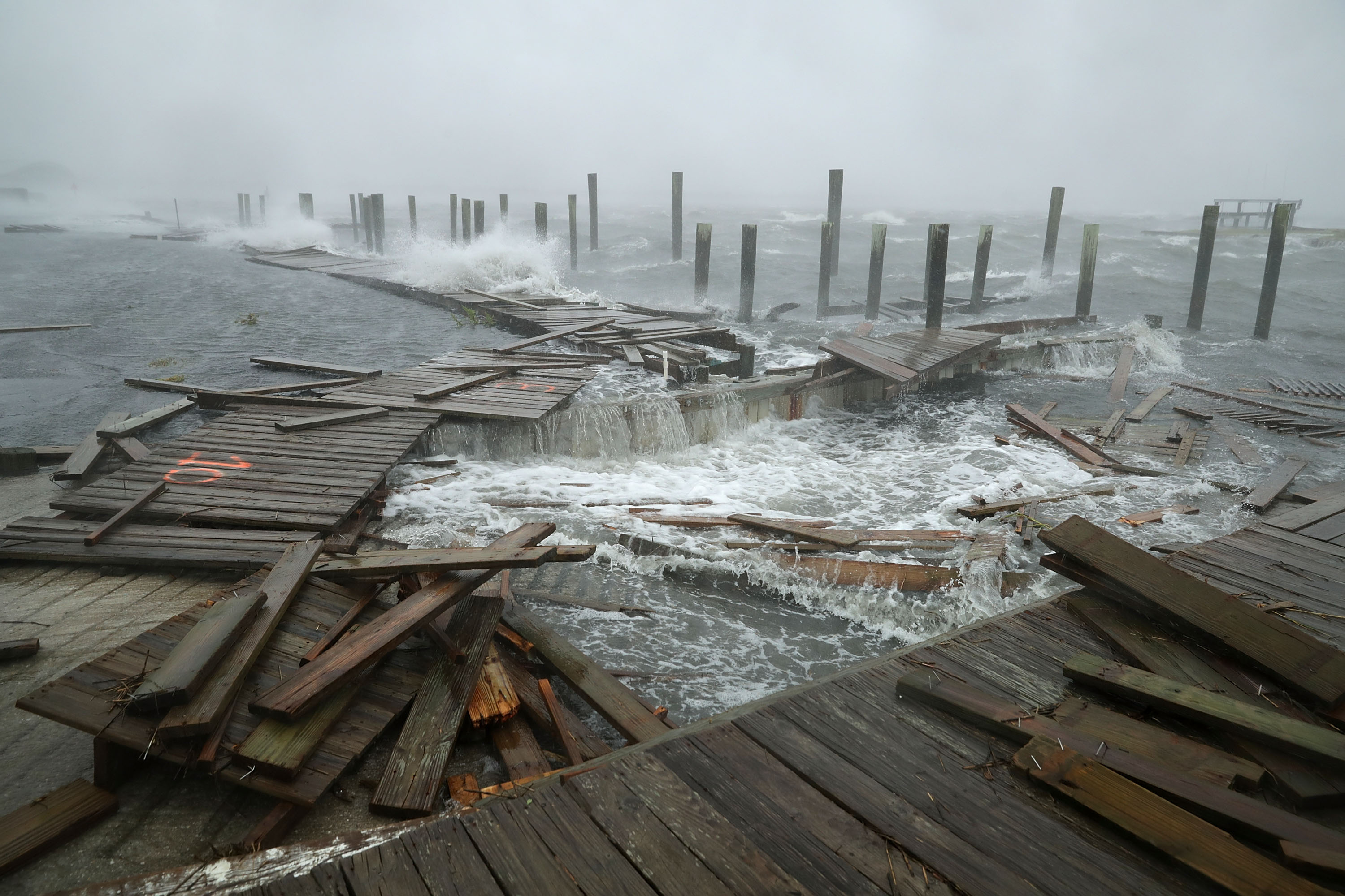 Portions of a boat dock and boardwalk are destroyed by powerful wind and waves as Hurricane Florence arrives September 13, 2018 in Atlantic Beach, United States. Coastal cities in North Carolina, South Carolina and Virginia are under evacuation orders as the Category 2 hurricane approaches the United States.
