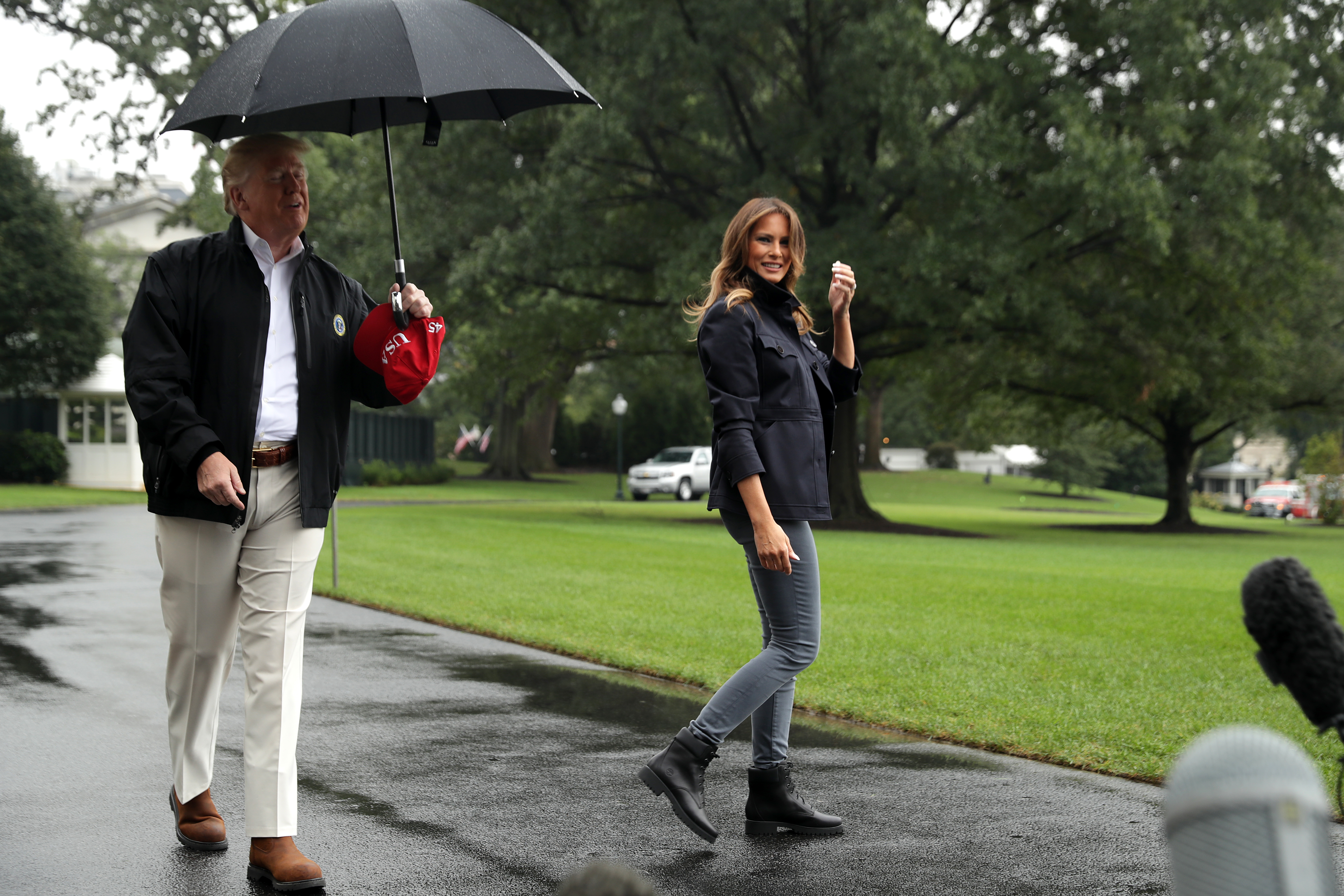 U.S. first lady Melania Trump waves to members of the press as she and President Donald Trump (L) leave the White House October 15, 2018 in Washington, DC.