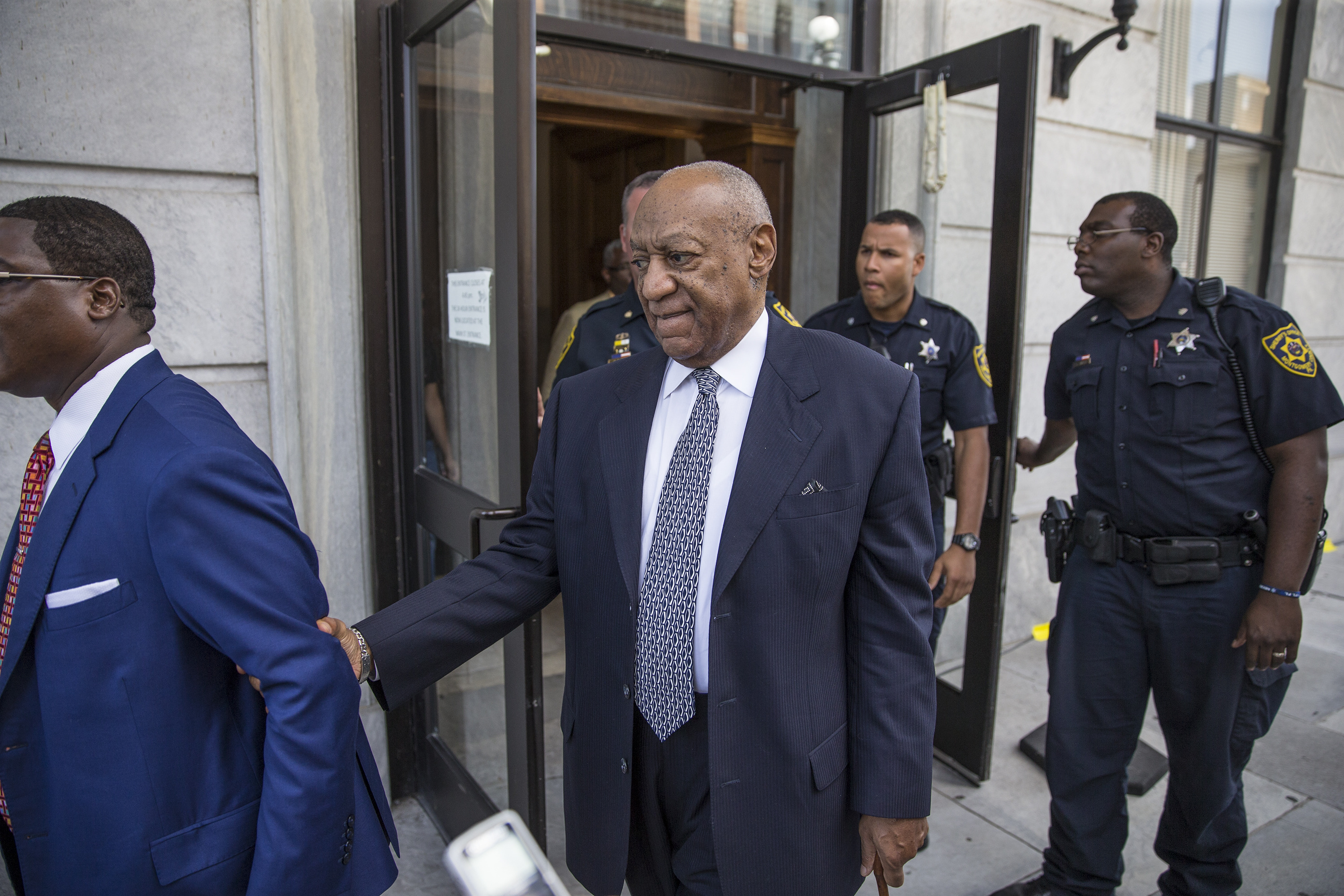 Bill Cosby leaves the Montgomery County Courthouse led by Andrew Wyatt, left, and following his legal team August 22, 2017 in Norristown, Pennsylvania. Bill Cosby and his new lawyers will have a hearing in Montgomery County Court about dropping his old counsel, adding his new counsel and if the jury pool will be taken out of county again.