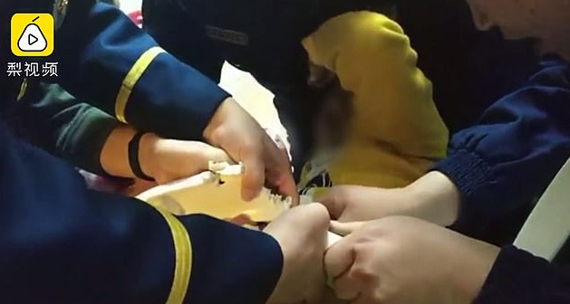 Supervisor Zhou consoled the youngster by chatting with him after firefighters were able to dismantle the toilet seat using pliers and their hands to break the rim. (YouTube)
