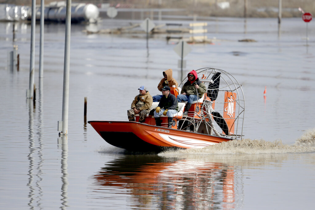 Gabe Schmidt, owner of Liquid Trucking, back right, travels by air boat with Glenn Wyles, top left, Mitch Snyder, bottom right, and Juan Jacobo, bottom left, as they survey damage from the flood waters of the Platte River, in Plattsmouth, Neb., Sunday, March 17, 2019 (AP)
