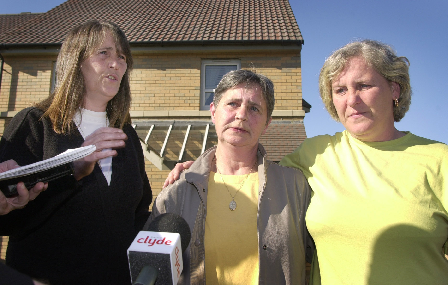 Mother Catherine Gallacher, 58, (centre) accompanied by daughter's Yvonne, (right) and Catherine, from her front garden in Glasgow, gives her reaction to the verdict delivered upon Angus Sinclair, 56, who was found guilty at Glasgow High Court (Source: Ben Curtis - PA Images/PA Images via Getty Images)