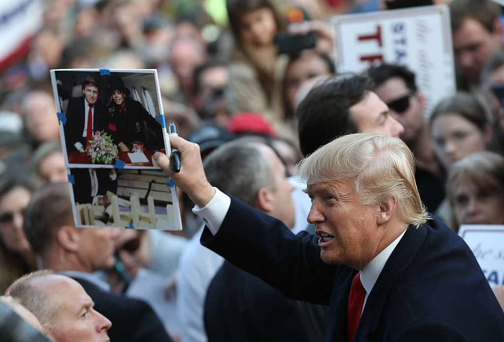 Republican presidential candidate Donald Trump holds up a photo of himself with pop star Michael Jackson that a member of the audience asked him to autograph after Trump addressed South Carolina voters on February 17, 2016 in Walterboro, South Carolina. (Photo by Win McNamee/Getty Images)