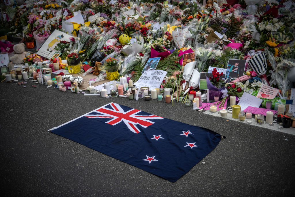 A New Zealand flag is placed next to flowers and tributes near Al Noor mosque on March 18, 2019 in Christchurch, New Zealand. 50 people were killed, and dozens are still injured in hospital after a gunman opened fire on two Christchurch mosques on Friday, 15 March (Getty Images)