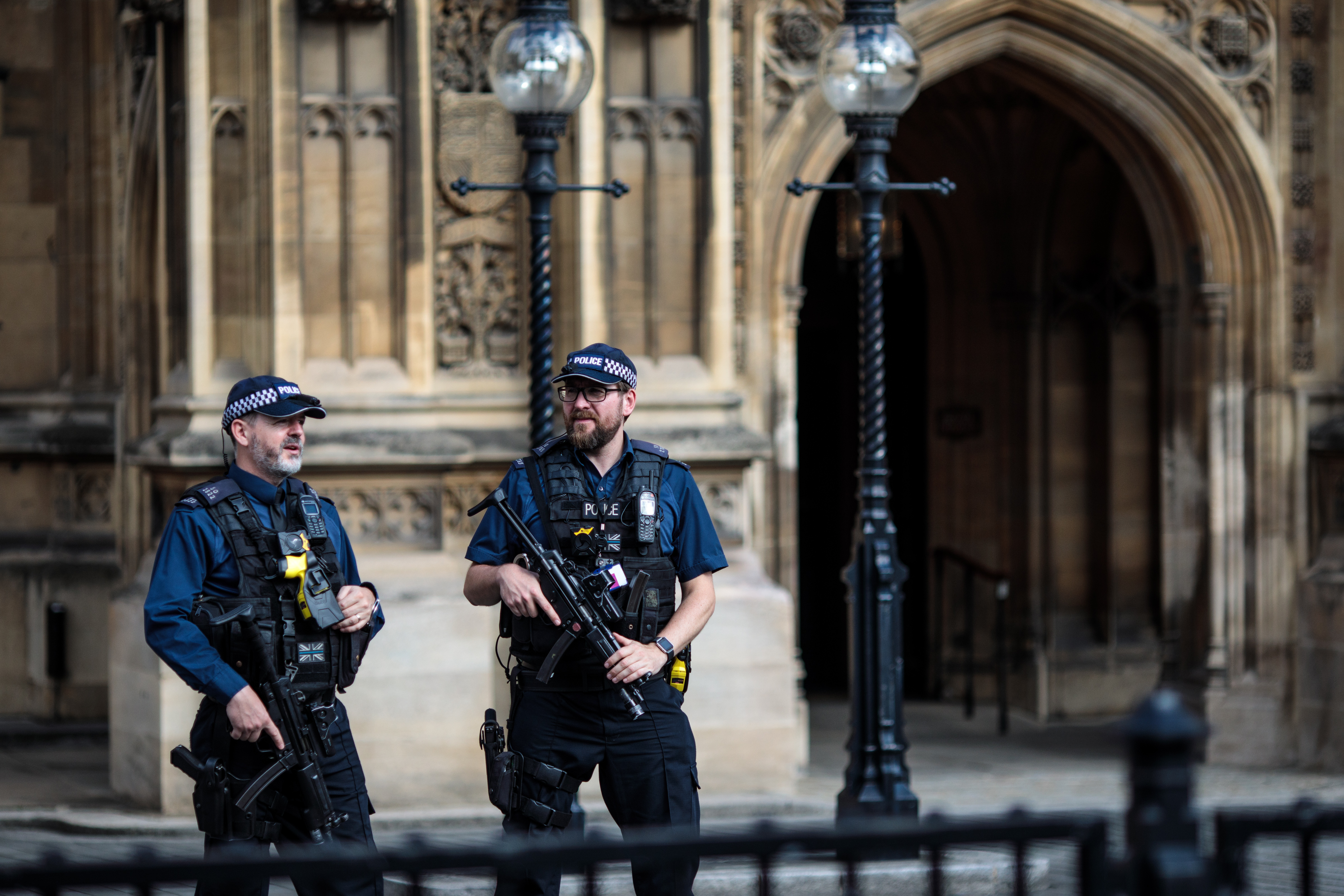 Armed police officers stand behind security barriers outside the Houses of Parliament following yesterday morning's incident, which is being investigated by terror police on August 15, 2018 in London, England.