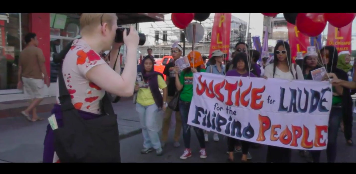 Journalist Meredith Talusan (L) takes a picture of protesters rallying for justice in Jennifer's case, in a still from Call Her Ganda.
