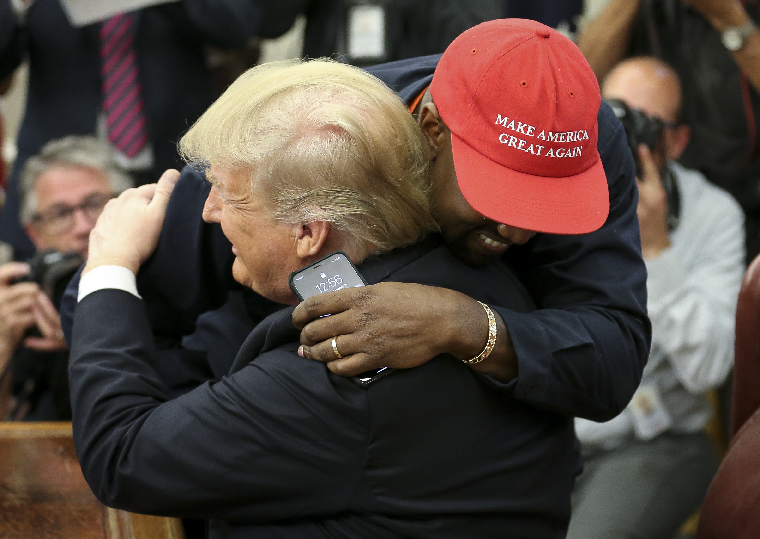 (AFP OUT) (EDITORS NOTE: Retransmission with alternate crop.) U.S. President Donald Trump hugs rapper Kanye West during a meeting in the Oval office of the White House on October 11, 2018 in Washington, DC.