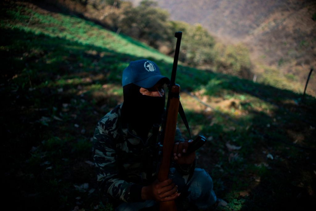 A Guerrero Community Police member patrols at an illegal poppy field, in Heliodoro Castillo, Guerrero state, Mexico, on March 25, 2018. - In the mountains of Guerrero, hundreds of impoverished families have depended for years on their poppies cultivation, a beautiful flower from which opium gum, the precursor of heroin, is obtained. But, recently they have been affected due to the emergence of a synthetic opioid that is 50 times stronger than heroin: the fentanyl, which negatively impacts in the price of the kilo of opium gum. (Photo PEDRO PARDO/AFP/Getty Images)