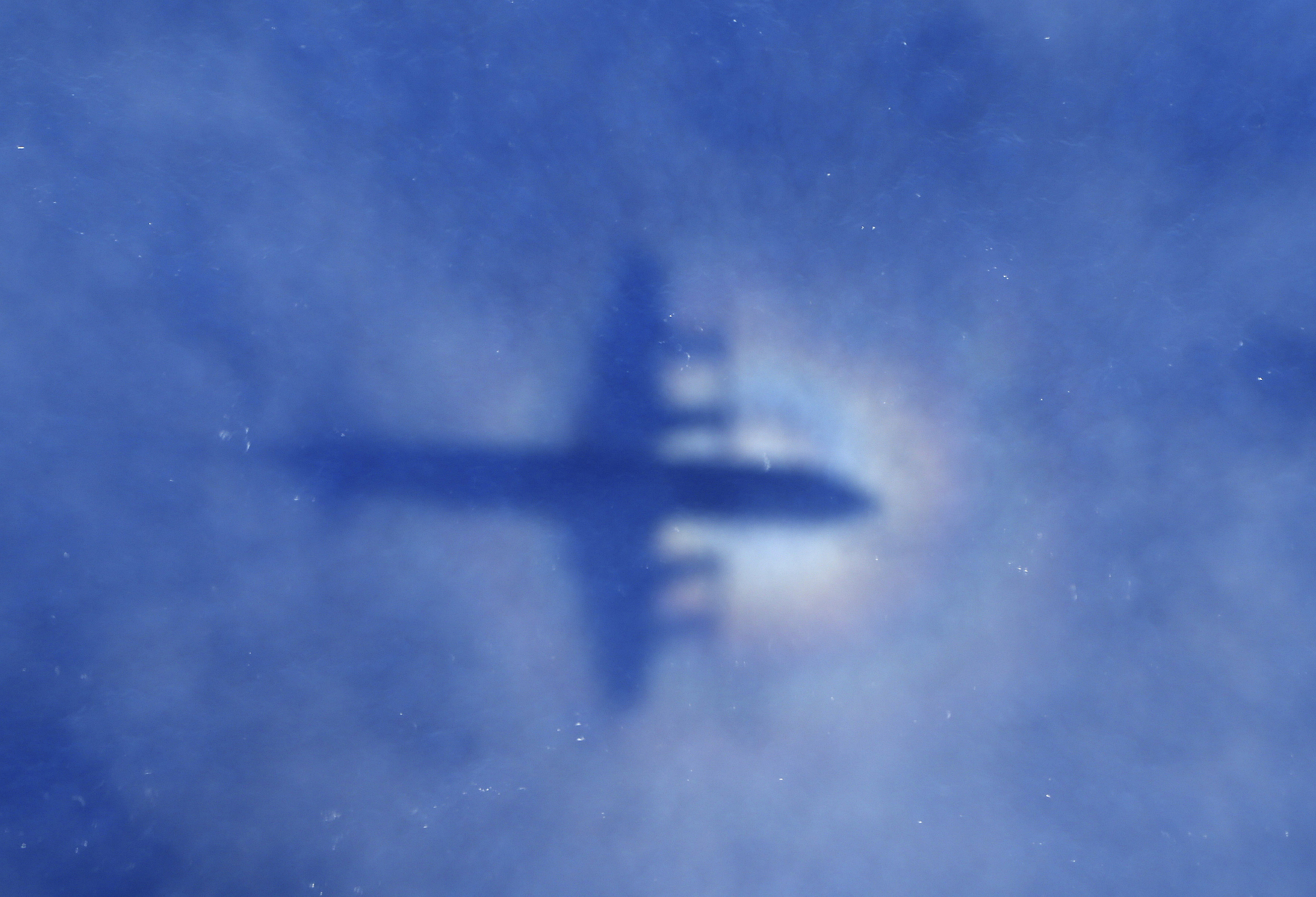 A shadow of a Royal New Zealand Air Force P3 Orion aircraft is seen on low cloud cover while it searches for missing Malaysia Airlines Flight MH370 (Source: Rob Griffith - Pool/Getty Images)
